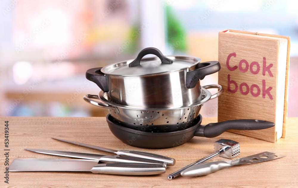 composition of kitchen tools and cook book on table in kitchen