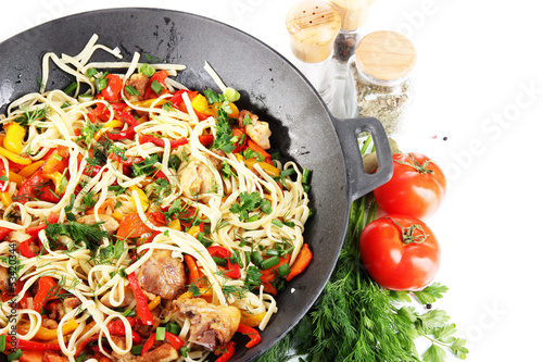 Fototapeta na wymiar Noodles with vegetables on wok isolated on white