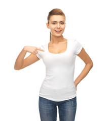 Wall Mural - smiling woman pointing at blank white t-shirt