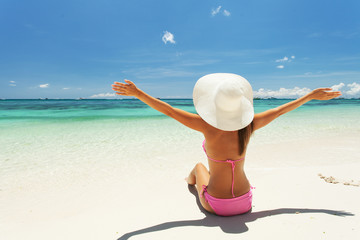 Wall Mural - Beautiful woman sits on the sand