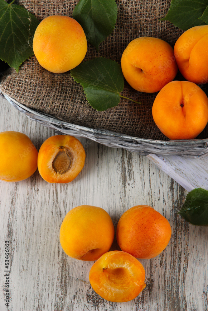 Apricots in basket on wooden table