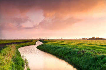 Fototapete - dramatic sunrise over canal in farmland