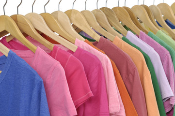 Variety of casual clothes Colors of rainbow on wooden hangers