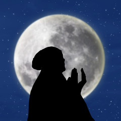 Silhouette of female muslim on blue moon