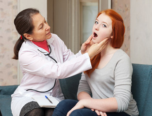 Wall Mural - doctor looks throat of teenage girl