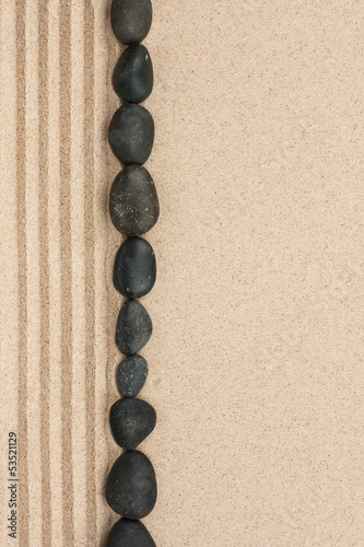 Fototapeta dla dzieci Stripe of black stones lying on the sand