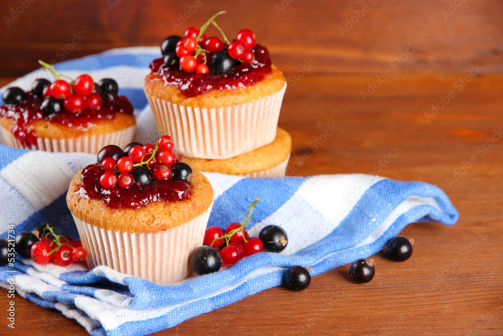 Tasty muffins with berries on wooden table