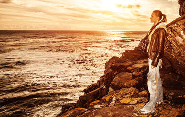 Wall Mural - Tourist girl on sunset on the cliff