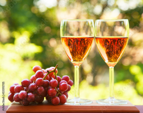 Fototapeta na wymiar Glass of pink wine and grape