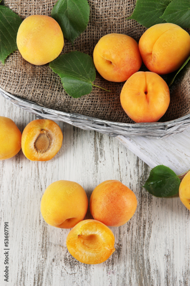 Apricots in basket on wooden table