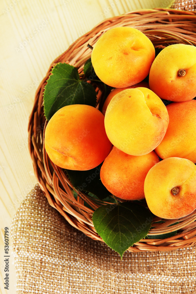 Apricots on wicker coasters on bagging on wooden table