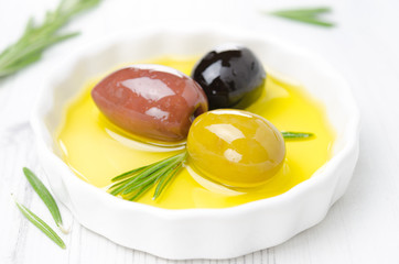 three kinds of olives and rosemary in bowl