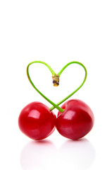 Heart shape from two cherries over white