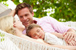© Monkey Business - Family Relaxing In Beach Hammock With Sleeping Daughter