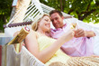 © Monkey Business - Couple Relaxing In Beach Hammock Drinking Champagne
