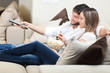 © Minerva Studio - Happy young couple watching television together at home
