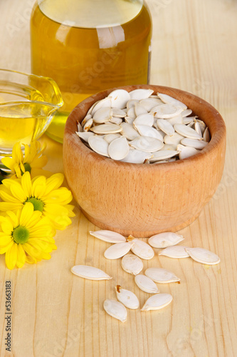 Naklejka dekoracyjna Useful pumpkin seed oil on wooden table close-up