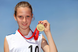 Fototapeta  - Uśmiechnięta dziewczyna ze złotym medalem.