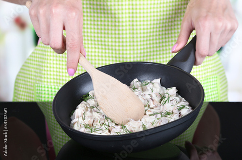 Fotografie, Obraz Hands cooking mushroom sauce in pan in kitchen