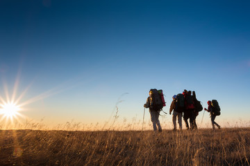 Wall Mural - Hikers is walking on plateau in Crimea mountains during sunset