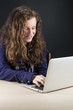 © Inus Grobler - Teen sitting at table with a laptop