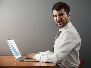 Canvas Print - angry businessman working with laptop