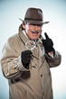 Vintage detective with mustache and hat. Looking through magnify