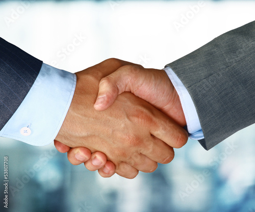 Naklejka - mata magnetyczna na lodówkę Closeup of a business hand shake between two colleagues