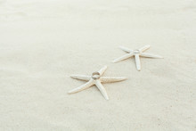 Wedding Rings With Starfish On A Sandy Beach.