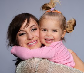 Happy young mother hugs her daughter