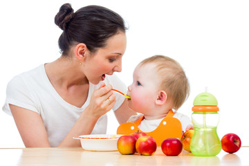 young mother feeding her daughter girl