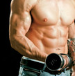 Handsome muscular man working out with dumbbells 