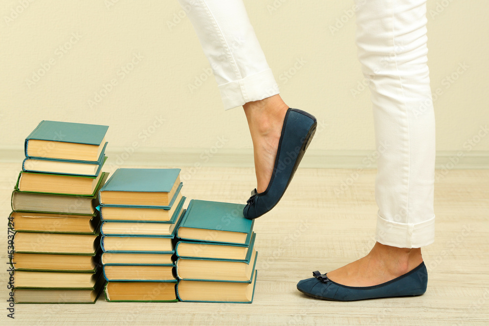 Girl climbs up on pile of books