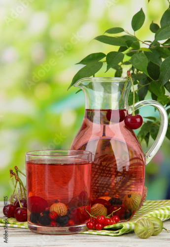 Fototapeta do kuchni Pitcher and glass of compote with summer berries