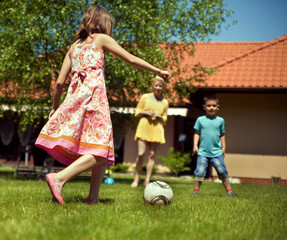 Happy family playing football in the garden