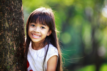 cute little girl smiling in a park close up
