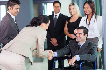 businesswoman greeting handicapped business partner