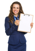 Smiling Business Woman Pointing In Blank Clipboard