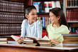 © Tyler Olson - Schoolgirls Looking At Each Other While Studying In Library