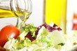 Close-up of bottle with pouring olive oil and vegetable salad