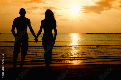 Foto-Vorhang - Couple enjoying their time at the sunrise on the beach (von iulianvalentin)