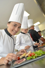 Wall Mural - Team of young chefs preparing delicatessen dishes