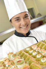 Wall Mural - Cheerful young cook holding plate of delicatessen