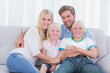 © WavebreakmediaMicro - Smiling family sitting on couch