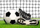 Fototapeta Sport - soccer ball and shoes in grass