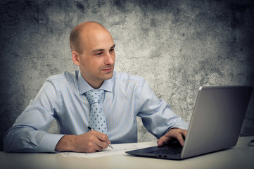 businessman with a laptop sitting at his desk