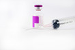 © khuntapol - Purple label ampule and disposable syringe on white background