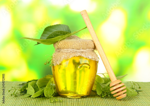 Fototapeta na wymiar Jar of honey with flowers of lime,