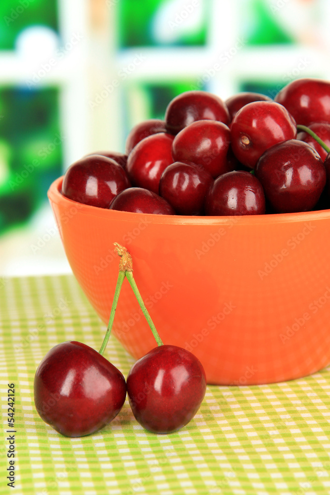 Cherry berries in bowl on table in room
