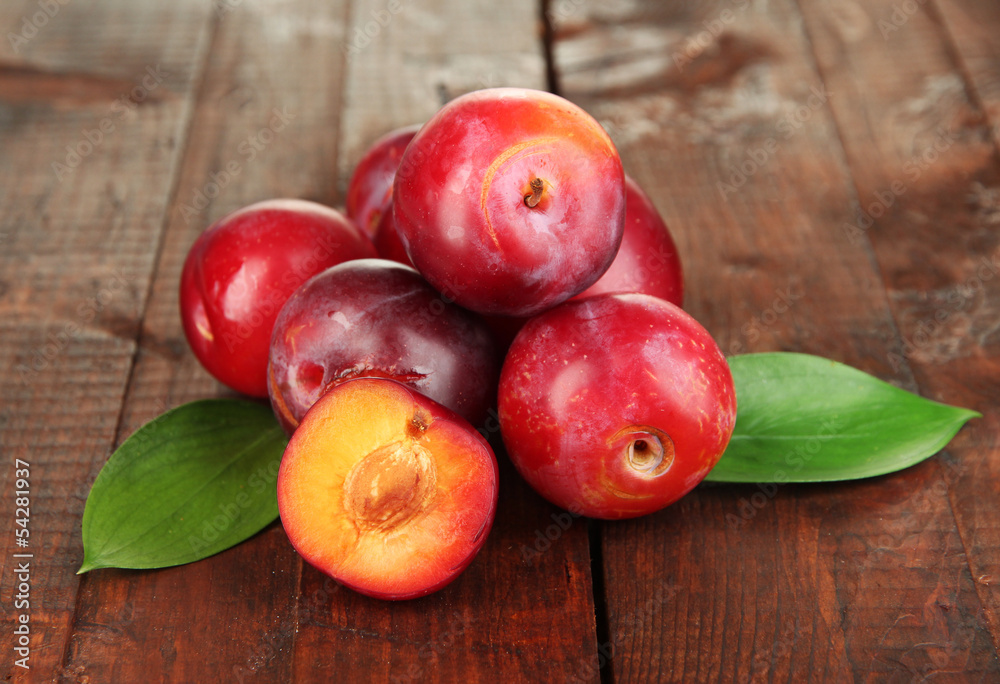 Ripe plums on wooden table close-up